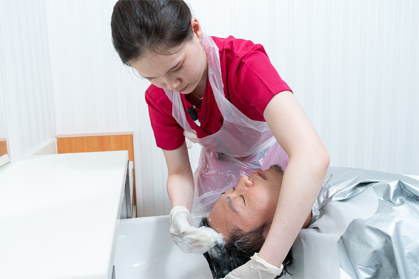 スタッフが患者様の頭を洗髪している様子